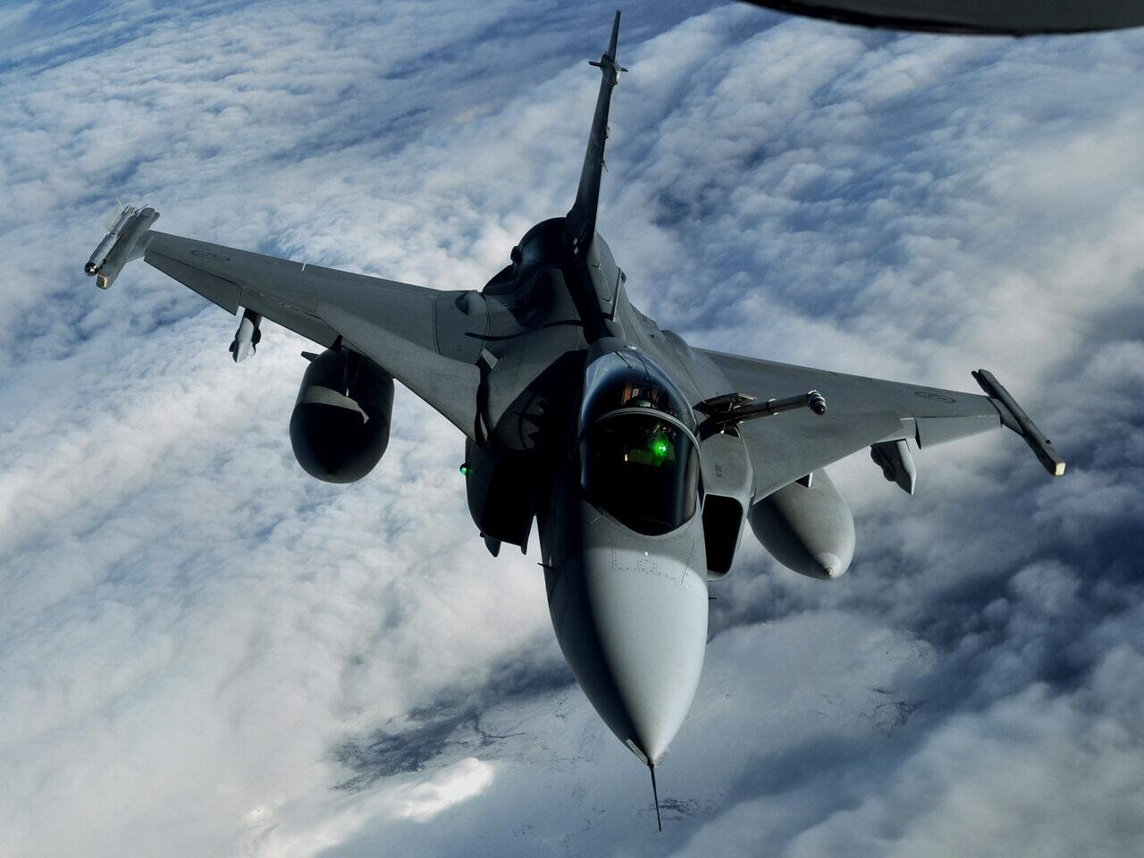 A Swedish JAS 39 Gripen photographed in flight above cloud